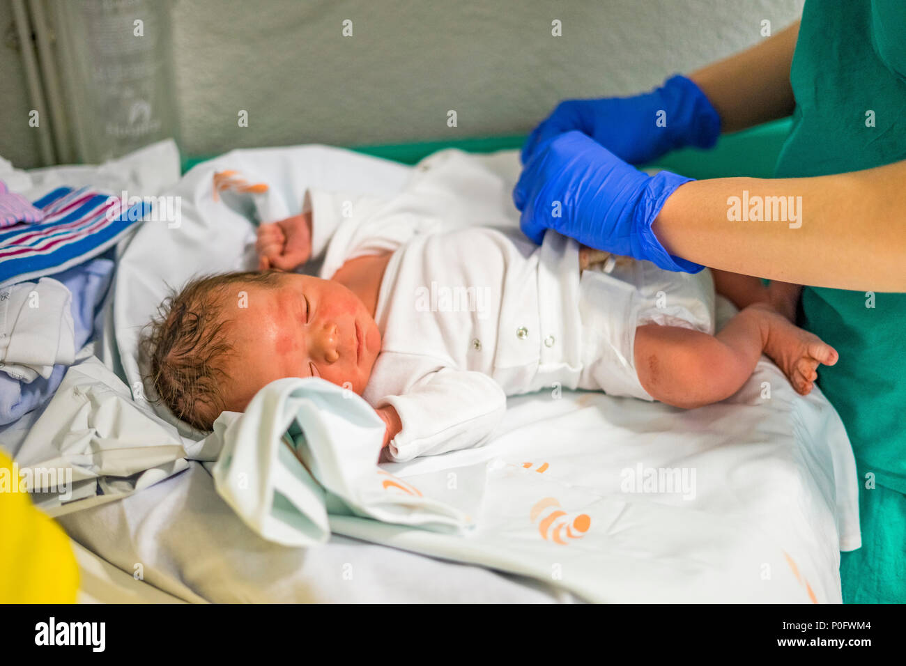 First dressing up of newborn baby boy done by nurse Stock Photo