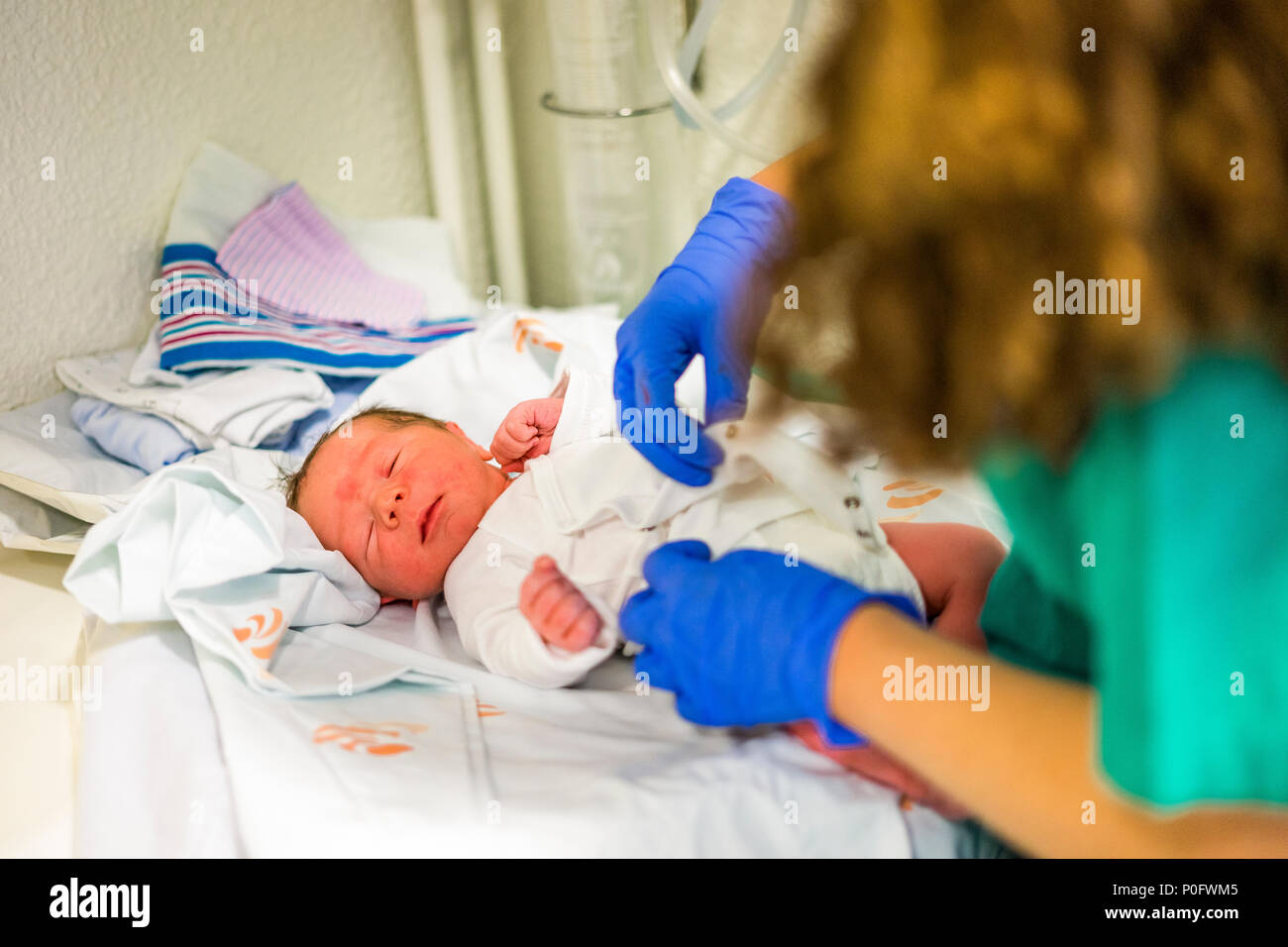 First dressing up of newborn baby boy done by nurse Stock Photo