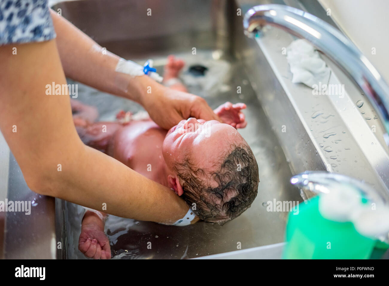 Mother bathing baby in sink hires stock photography and images Alamy