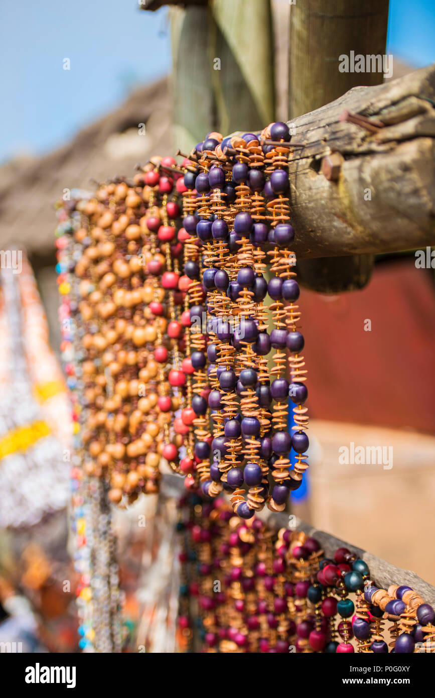 Beautiful African beaded necklaces hanging from a wood beam in an open air  market Stock Photo - Alamy