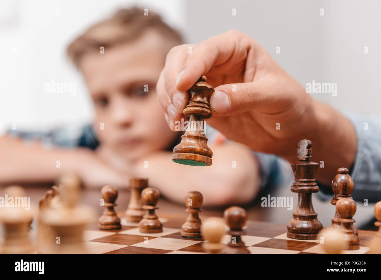 Woman Hand Holding a White Queen Piece Over a Chess Board