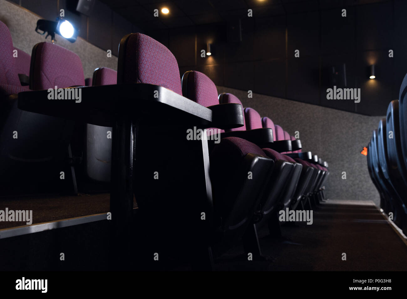 red seats in empty dark movie theater Stock Photo - Alamy
