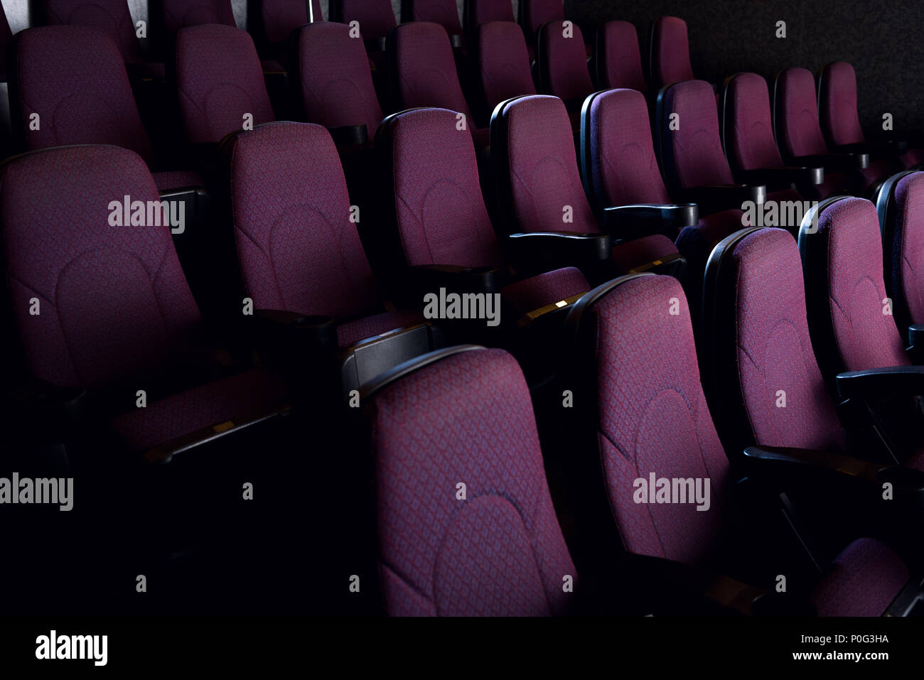 red seats in empty dark movie theater Stock Photo - Alamy