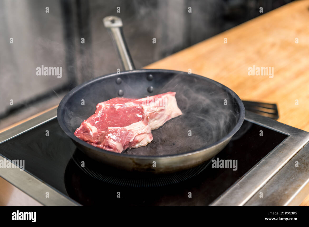 https://c8.alamy.com/comp/P0G3K5/raw-meat-on-frying-pan-on-electric-stove-P0G3K5.jpg