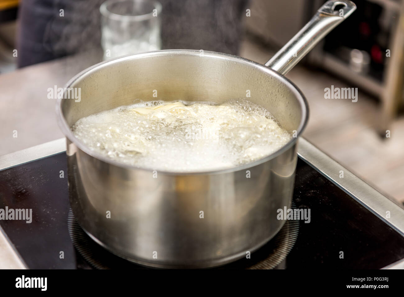 pasta in boiling water in pot on electric stove Stock Photo
