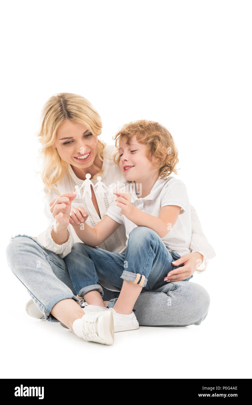 smiling mother and son holding paper family model in hands isolated on white Stock Photo