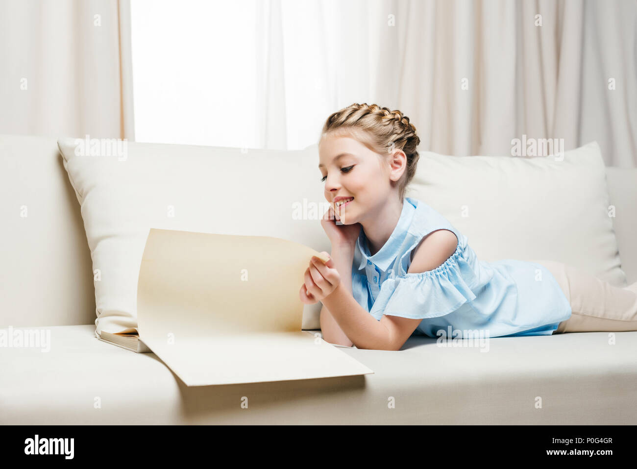 Smiling girl reading book hi-res stock photography and images - Alamy