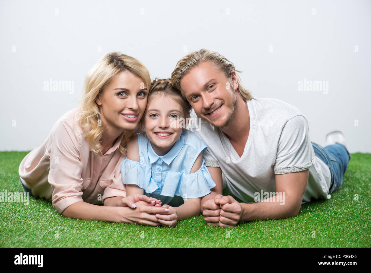 portrait of happy family lying on the grass and looking at camera Stock ...