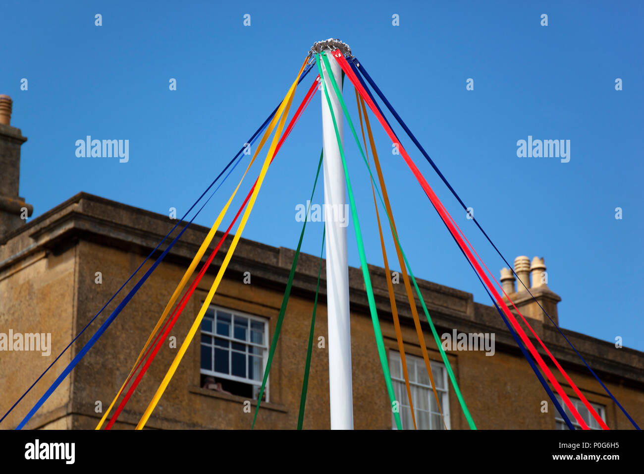 Colourful ribbons of maypole in front of cotswold stone building, Chipping Campden, Gloucestershire, England, United Kingdom, Europe Stock Photo