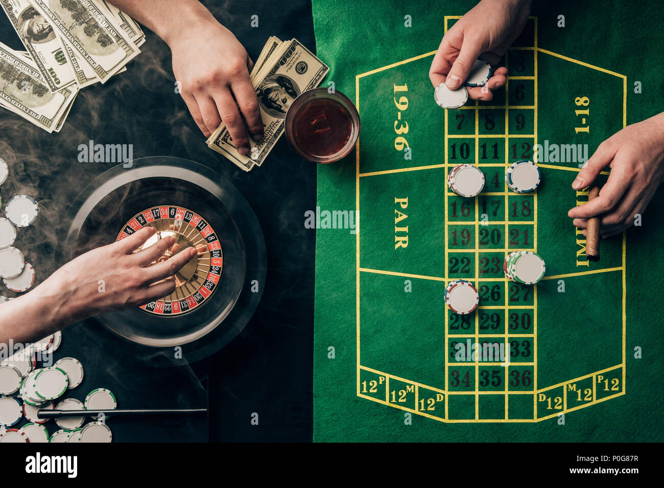People placing bets while playing roulette on casino table Stock Photo ...