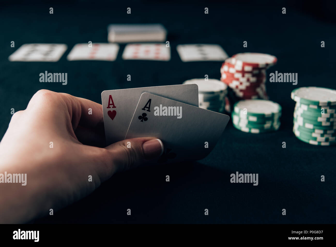 Woman holding playing cards by casino table Stock Photo - Alamy