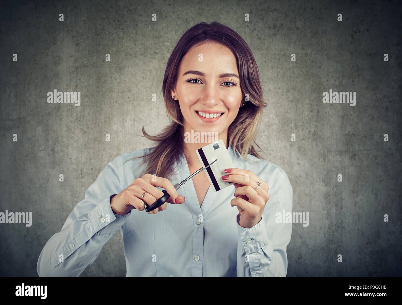 Cheerful young business woman looking happily at camera done with credit cards. Stock Photo