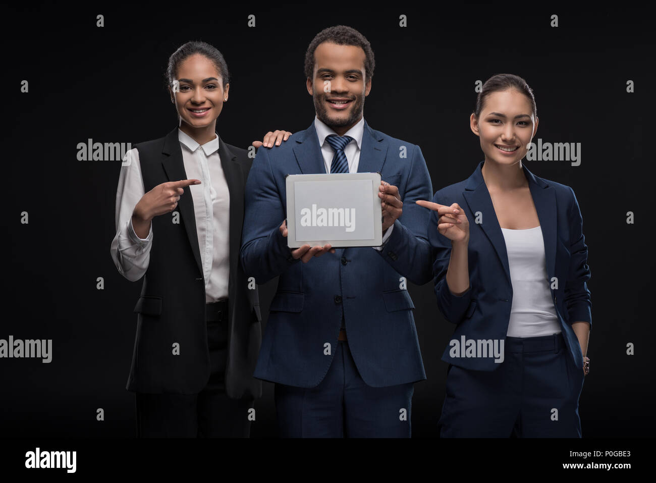 Business colleagues showing digital tablet and pointing on blank screen ...