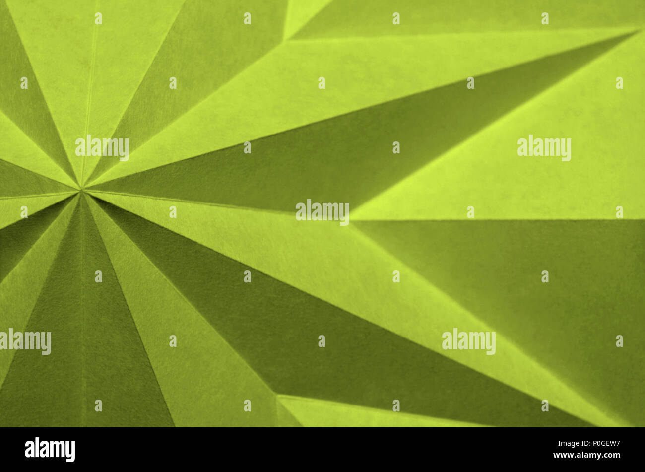 Lime Punch, Pantone 13-0550 . yellow green background abstract wallpaper. Origami; shallow focus, angular, monochrome folded paper. Stock Photo