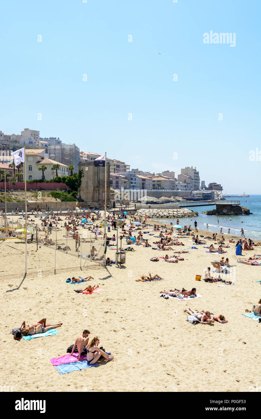 General view of the Catalans beach by a warm and sunny summery day with people enjoying the seaside by sunbathing and playing on the beach. Stock Photo