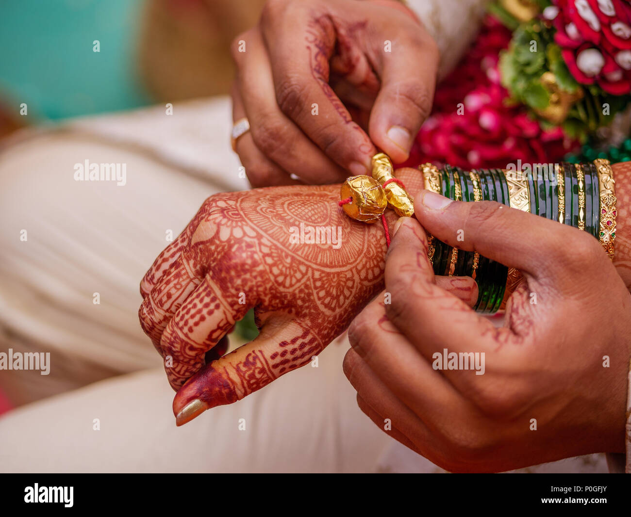 The close-up shot of kankan or halkund with thread on wrist of bride/groom performing ritual in maharashtrian wedding ceremony Stock Photo