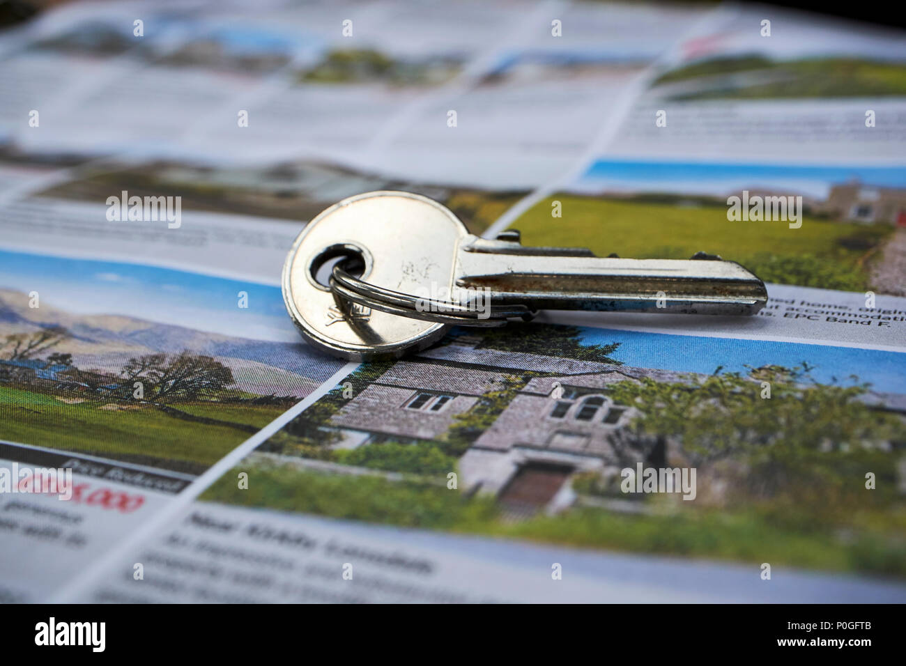 key to a vacation rental holiday home on a property sales magazine in the Lake District Cumbria England UK Stock Photo