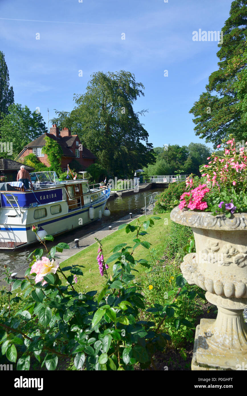 Summer plants flowering at the Sonning Lock with motorboat going through.  Sonning-on-Thames, Berkshire, UK, Great Britain Stock Photo