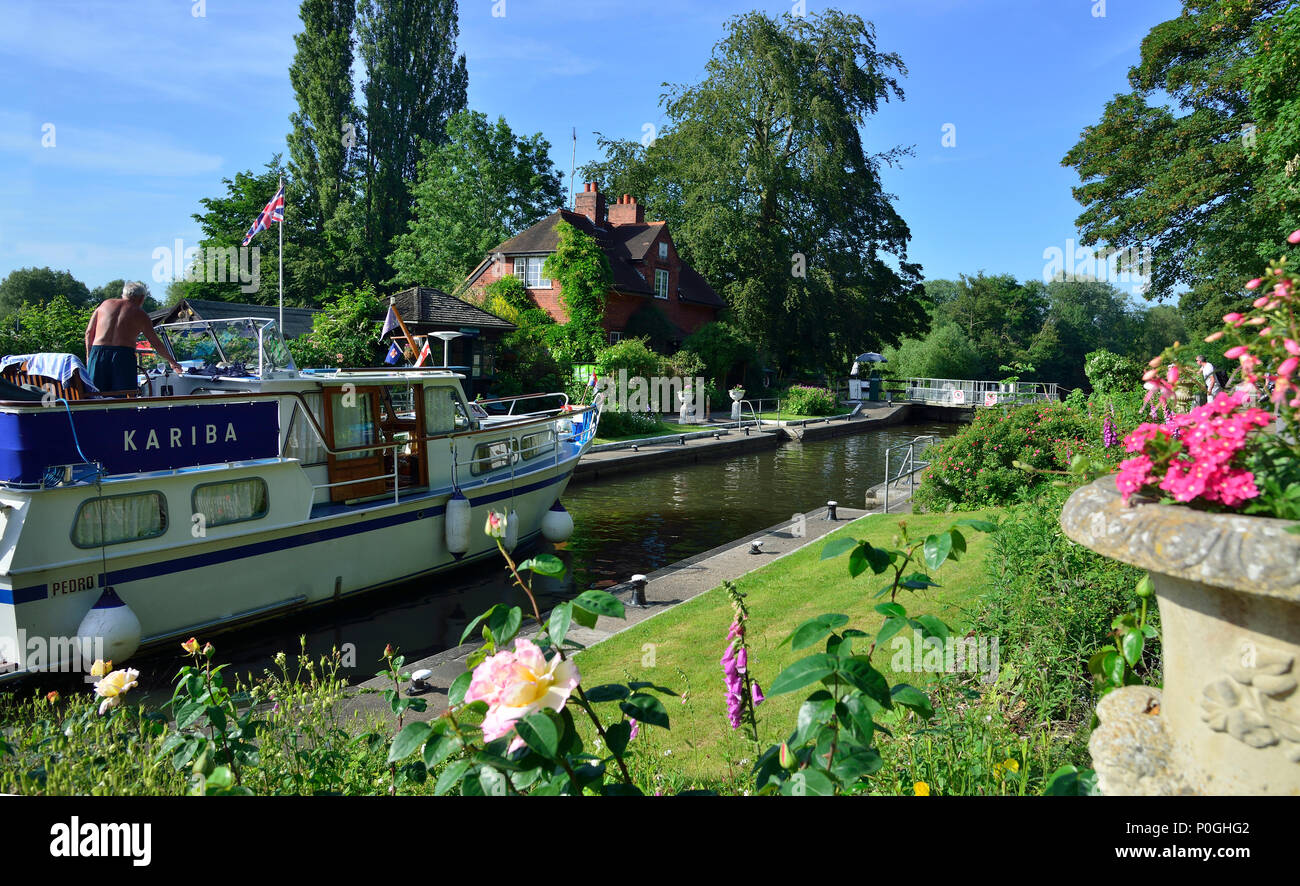 Summer plants flowering at the Sonning Lock with motorboat going through.  Sonning-on-Thames, Berkshire, UK, Great Britain Stock Photo