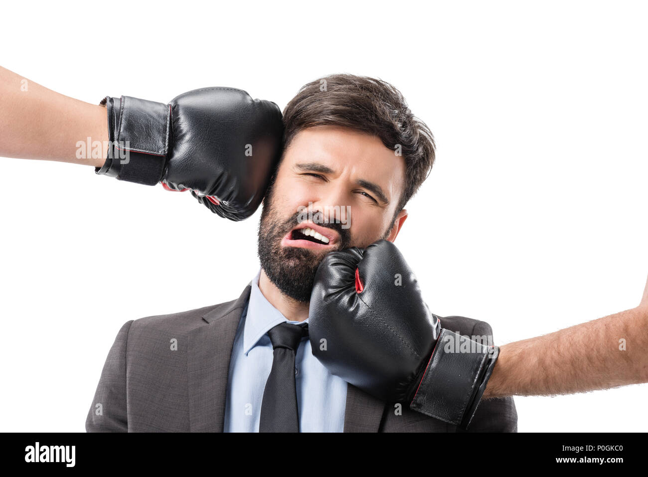portrait of businessman getting punched by boxers isolated on white