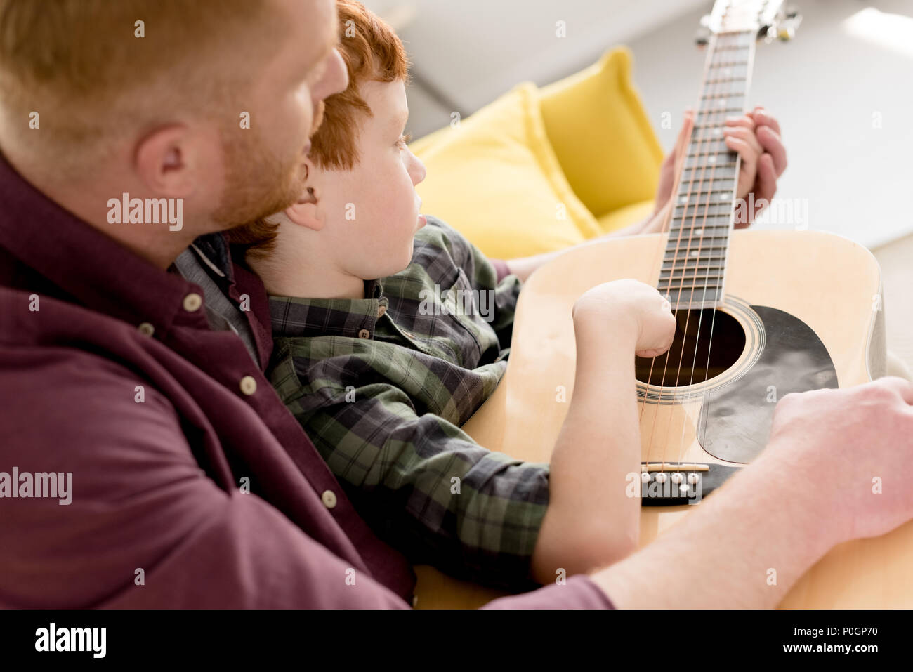 cropped shot of father teaching little son playing acoustic guitar Stock Photo