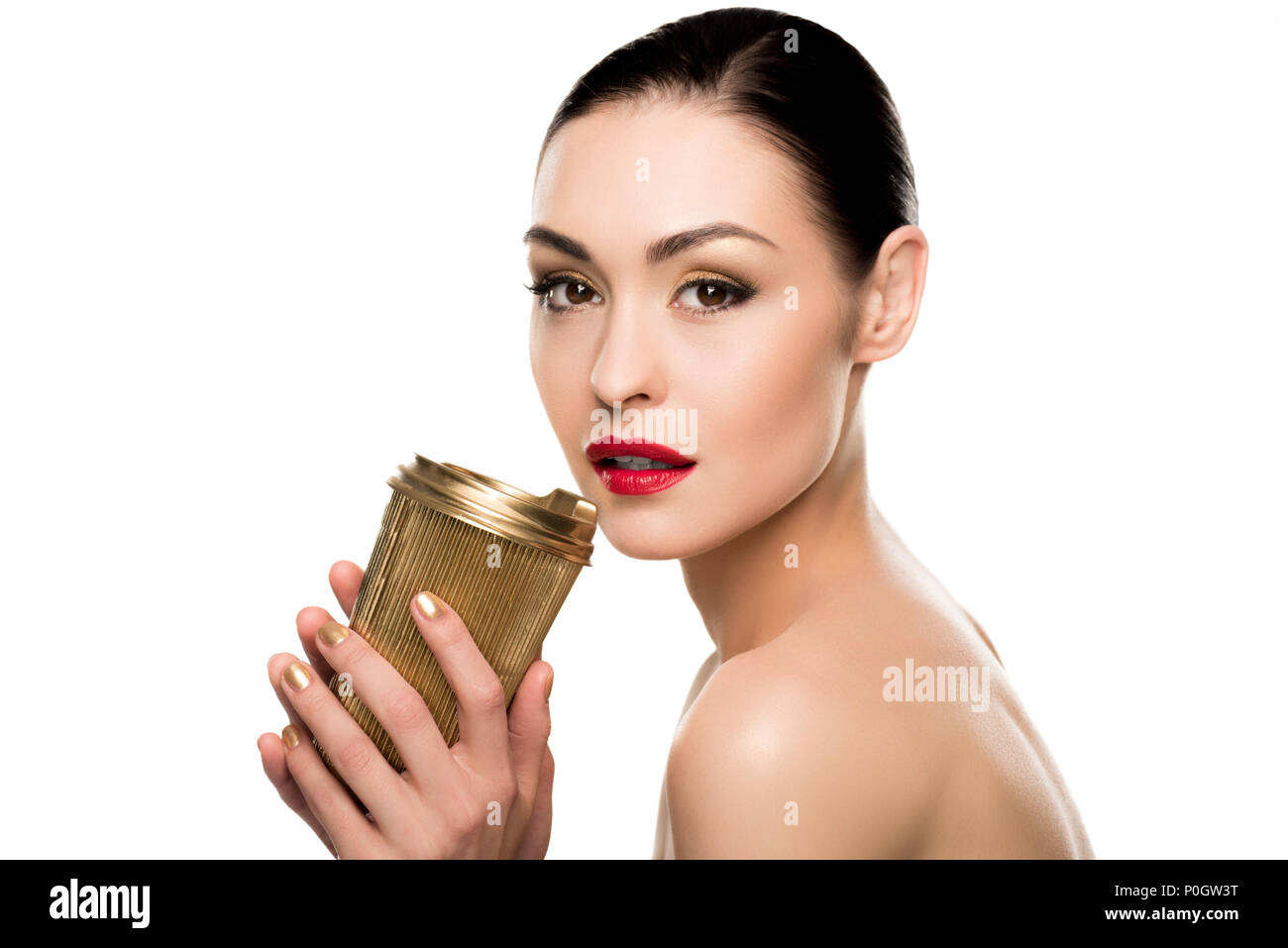 Sensual young woman holding golden paper cup and looking at camera ...