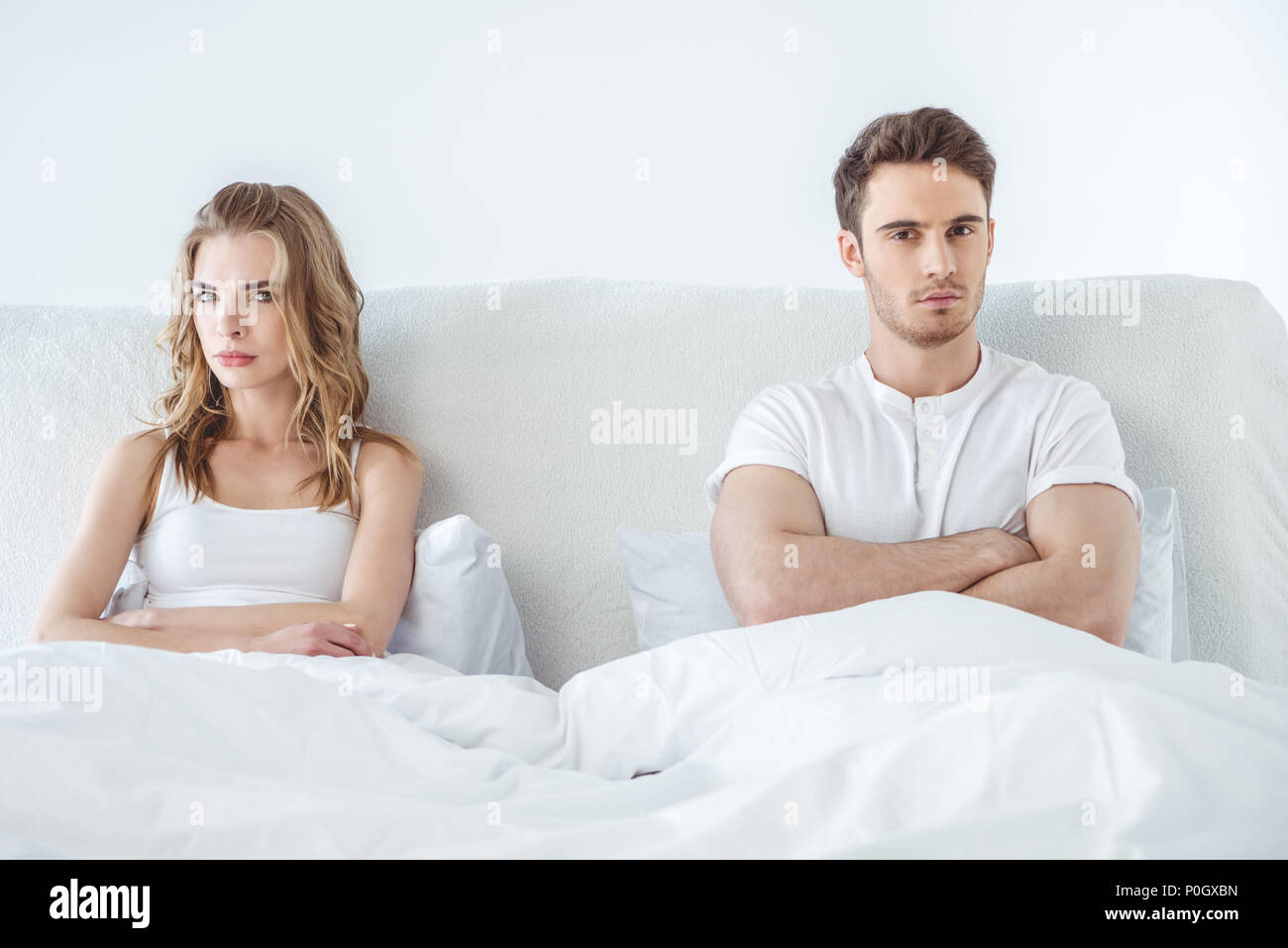 young dissatisfied couple lying in bed, relationship difficulties concept Stock Photo