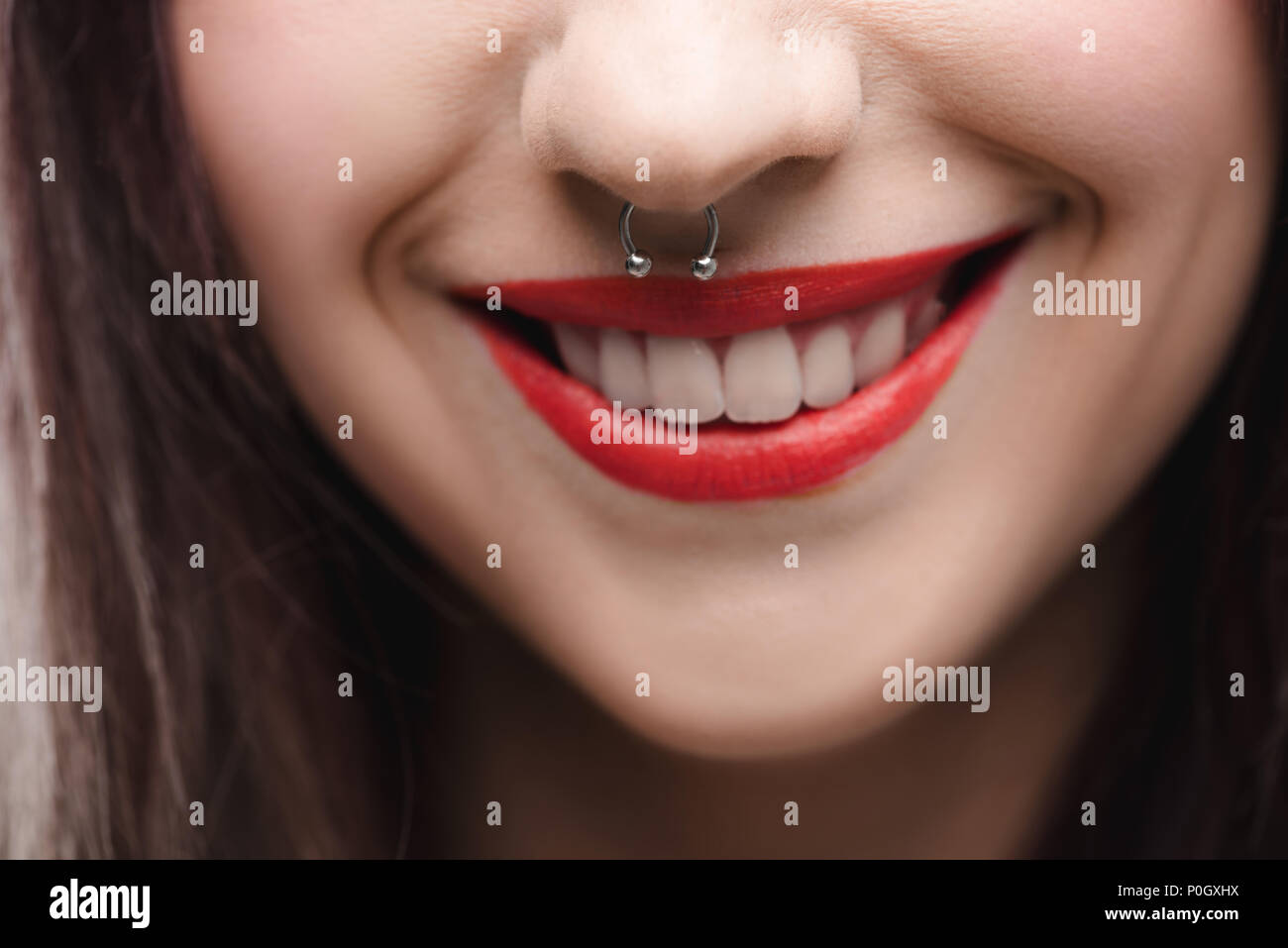 close up view of young girl with red lips and piercing in nose Stock Photo