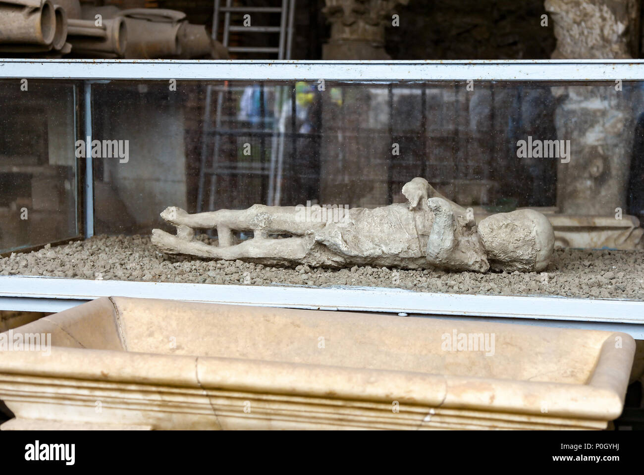 Plaster cast of a small child in a glass case, from the eruption of Vesuvius in AD 79 at the Pompeii Archaeological site, Pompeii, Campania, Italy, Stock Photo