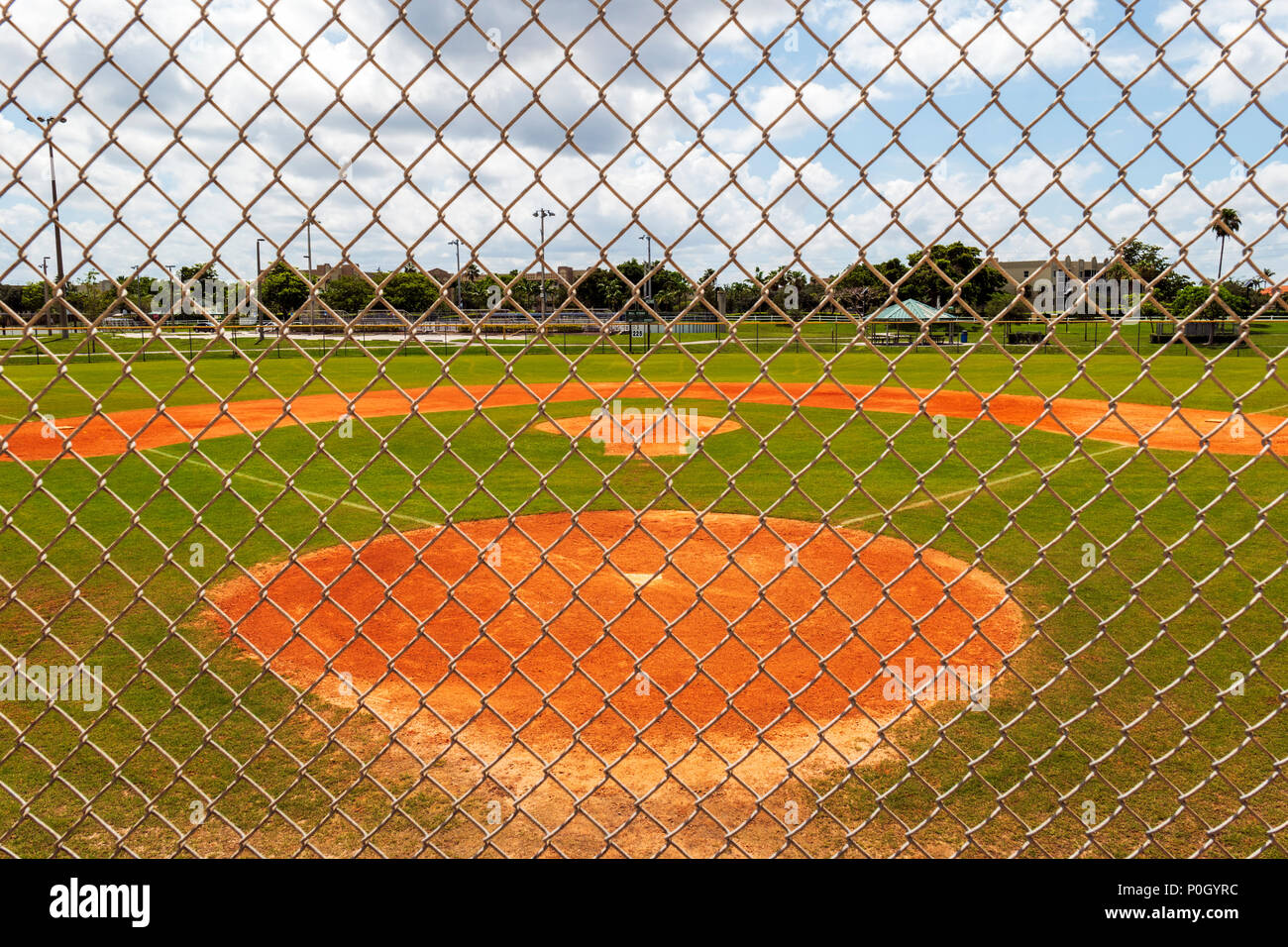 Public park baseball diamond viewed through cyclone fence; south