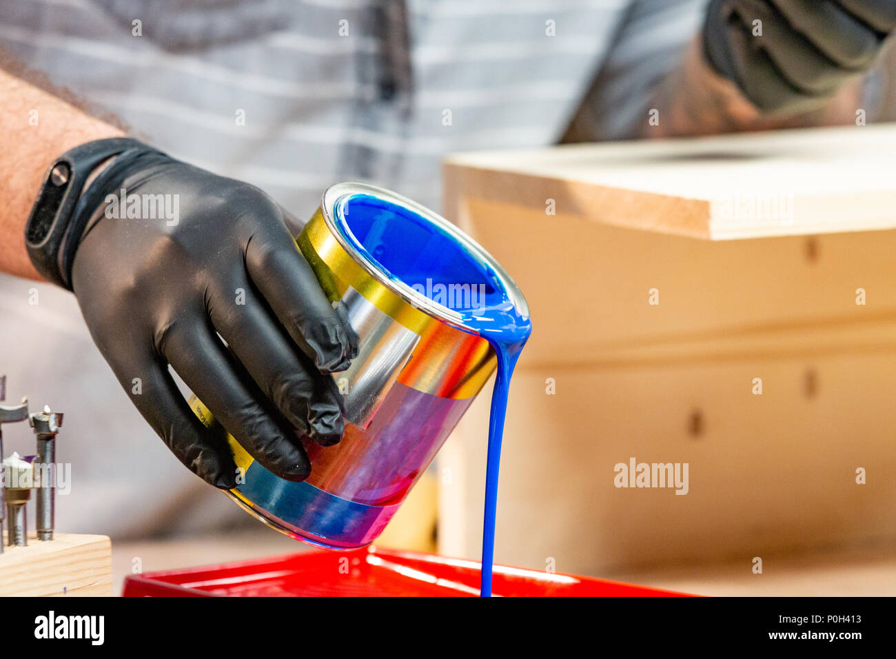 Male hand in gloves pouring paint into tray, closeup Stock Photo Alamy