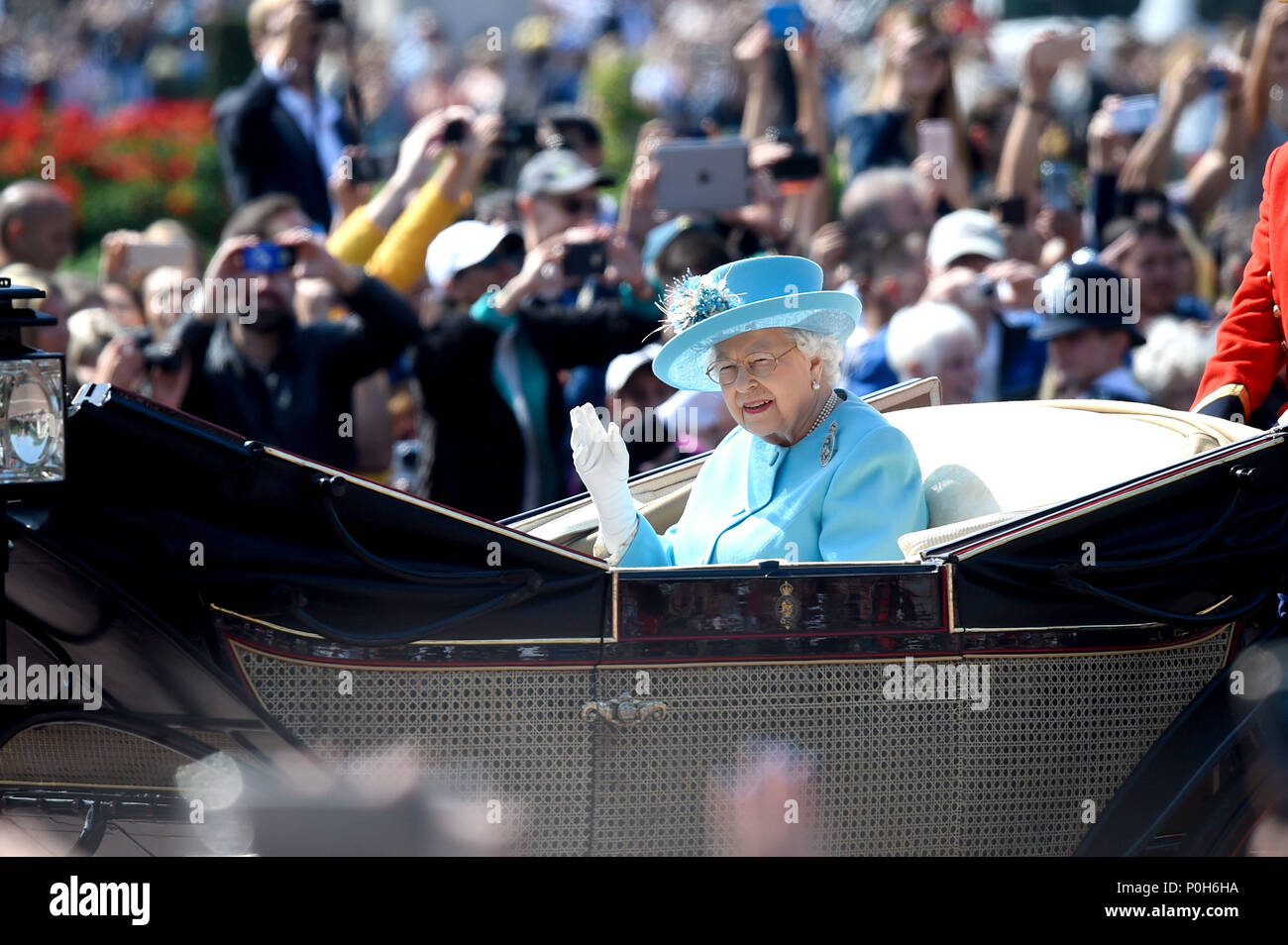 Queen Elizabeth II, waves to the crowds as she in rides in a carriage as it makes its way up The Mall from Buckingham Palace, central London to Horse Guards Parade, ahead of the Trooping the Colour ceremony, to celebrate her official birthday. Stock Photo
