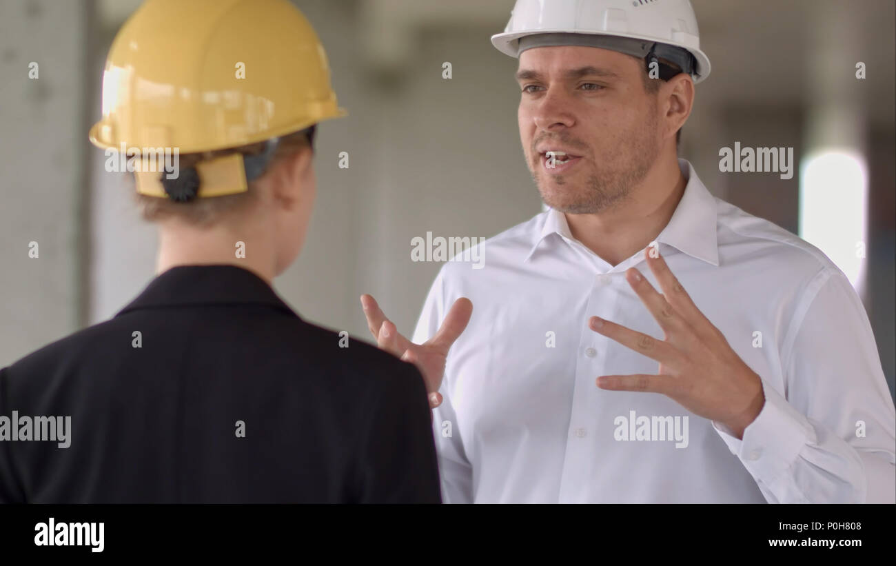 Two colleagues in the work plan discussing at a construction site Stock Photo