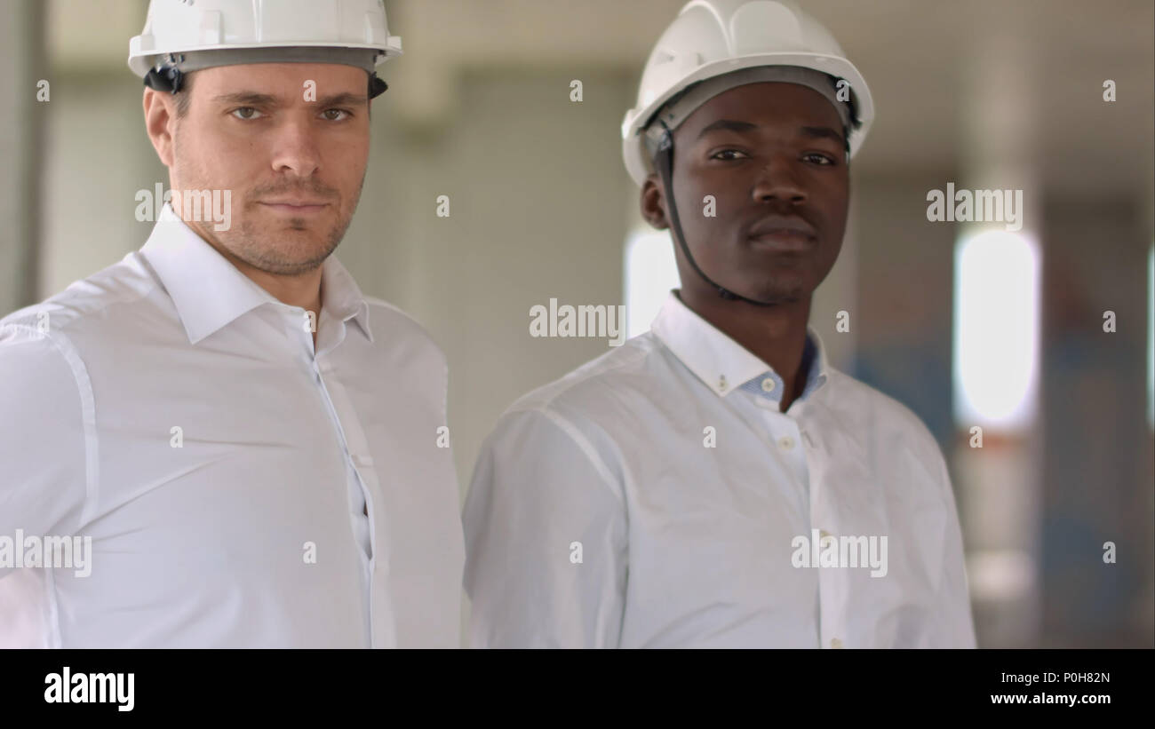 Two businessman looking at camera inside construction site Stock Photo