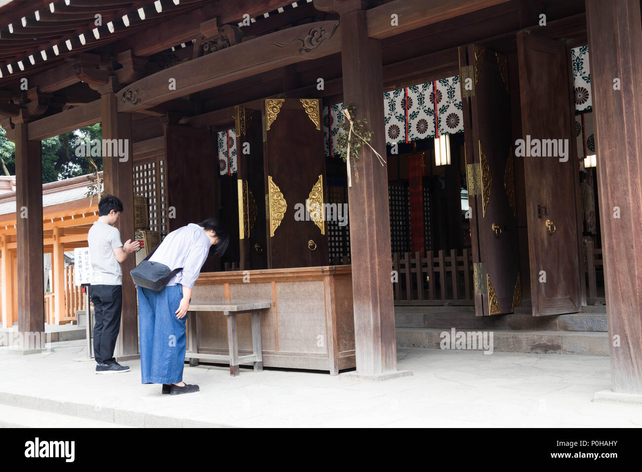 Worshipper bowing in prayer at Hikawa Jinja shrine, Omiya, Saitama, Japan Stock Photo