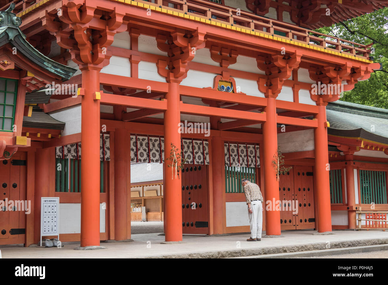 Man bowing  at temple gate  before entering, Hikawa Jinja shrine, Omiya, Saitama, Japan Stock Photo