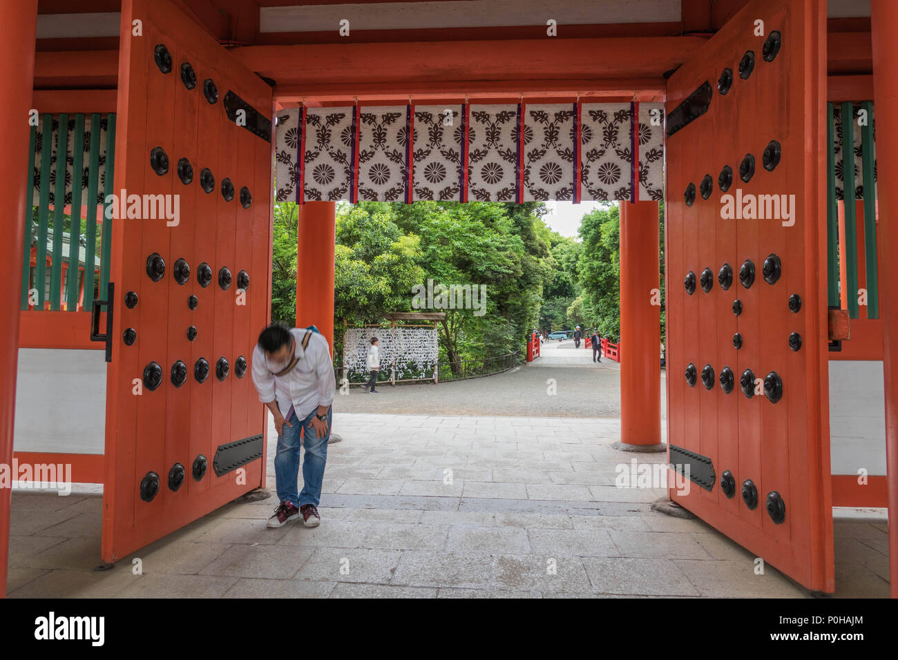 Man bowing  at shrine gate  before entering, Hikawa Jinja shrine, Omiya, Saitama, Japan Stock Photo