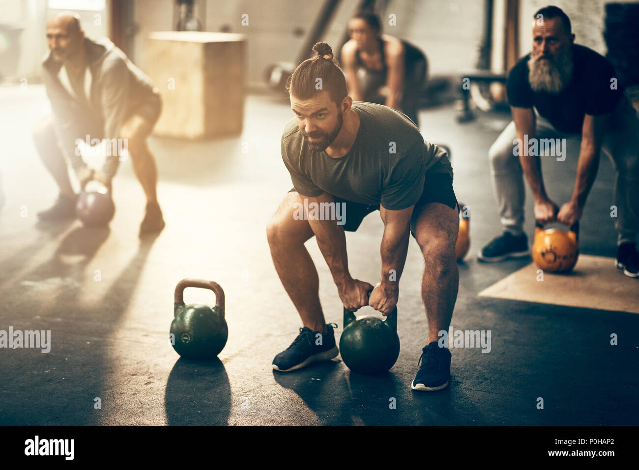 Fit group of people working out with weights together during an exercise  class at a gym Stock Photo - Alamy