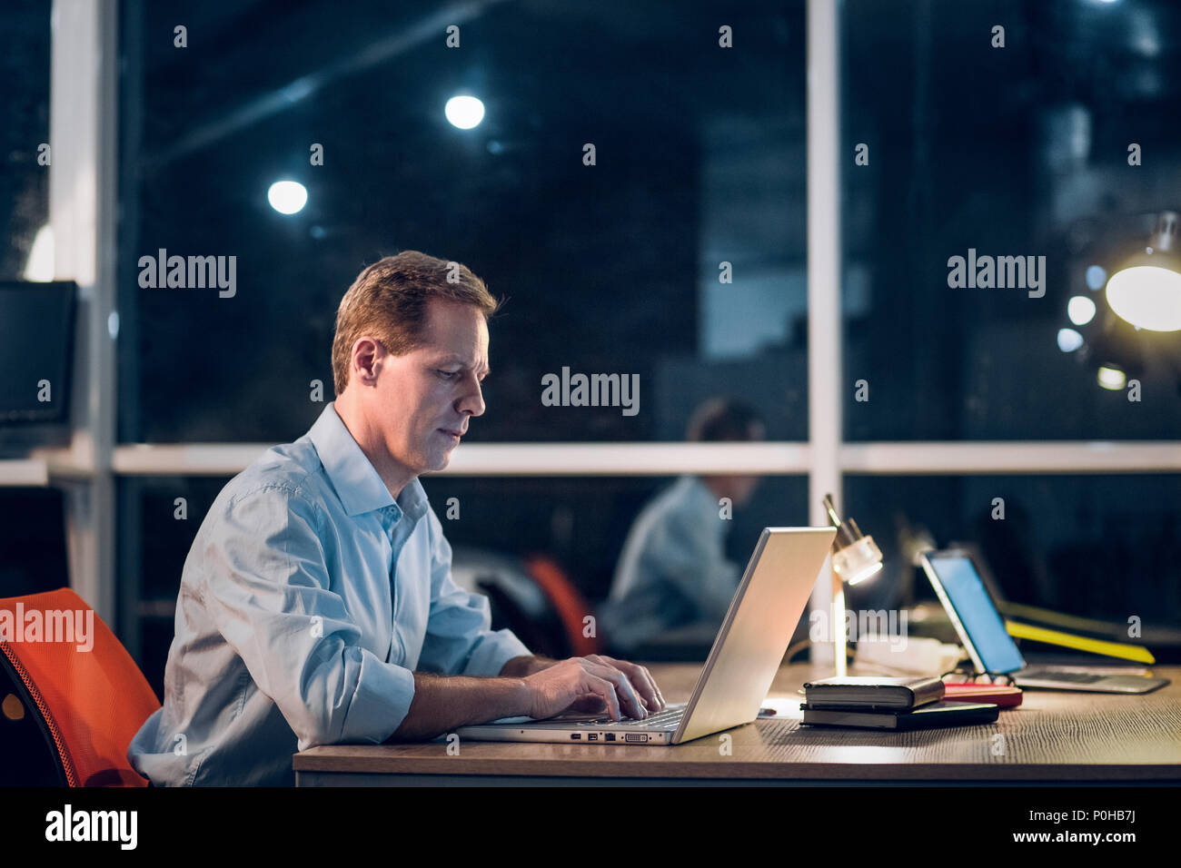 Businessman working with computer late at night. Stock Photo