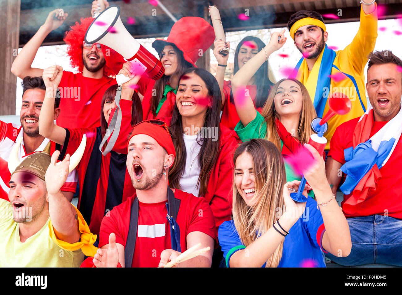 group of fans dressed in various colors watching a sports event in the