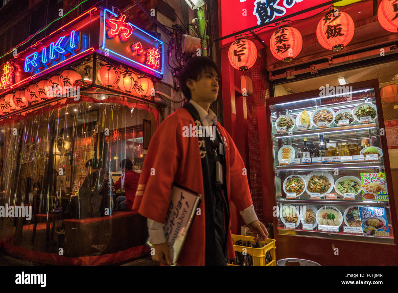 Street restaurants, with shokuhin sanpuru, food samples, man walking by on night street, Omiya,  Saitama, Japan Stock Photo