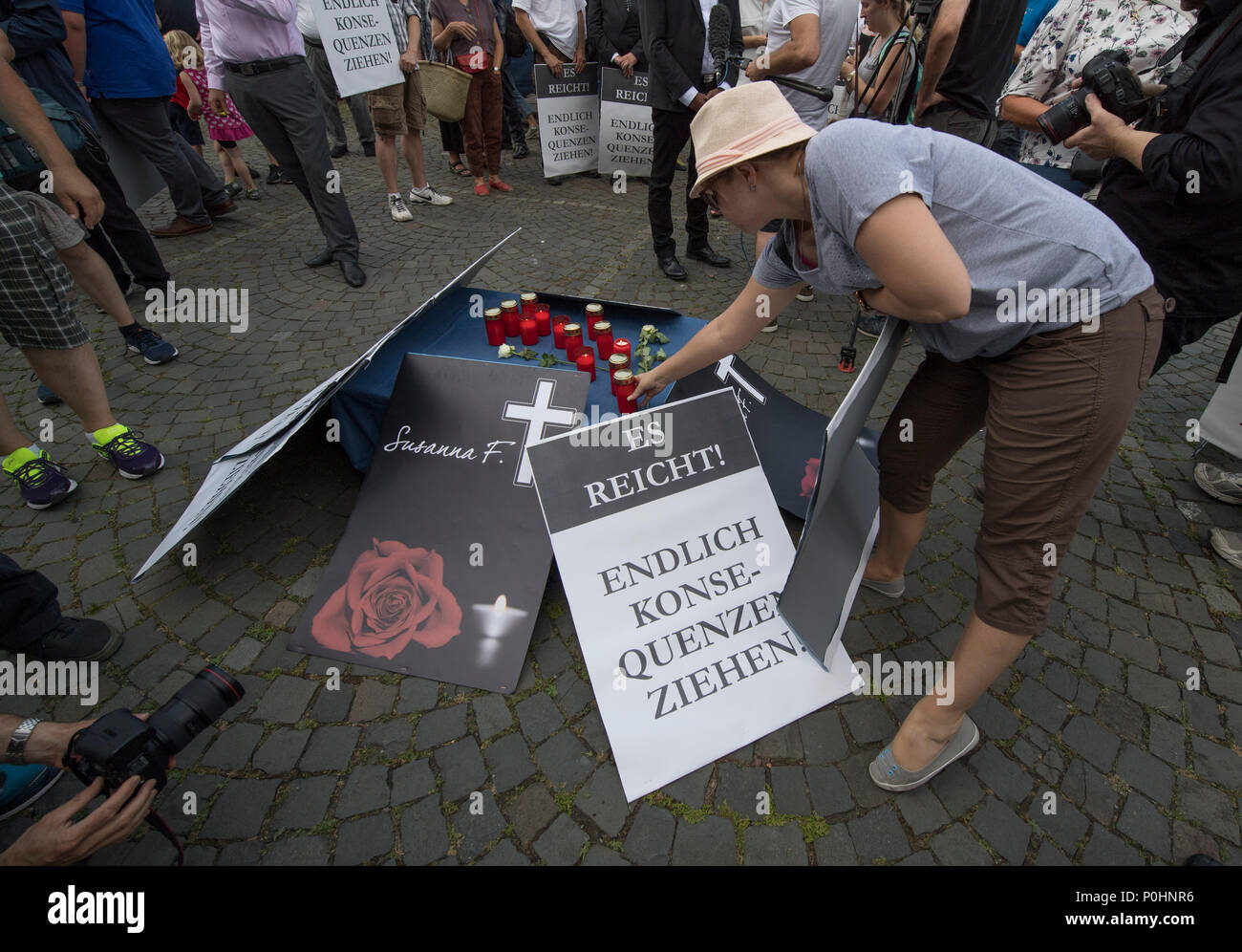 09 June 2018, Germany, Mainz: A few dozen people gather at a vigil organised by the Alternative for Germany (AfD) to commemorate 14-year-old murder victim Susanna. They light candles and carry signs reading 'Es reicht! Endlich Konsequenzen ziehen!' (lit. 'Enough! Consequences should follow'). An Iraqi refugee is suspected of having raped and murdered the girl. Photo: Boris Roessler/dpa Stock Photo