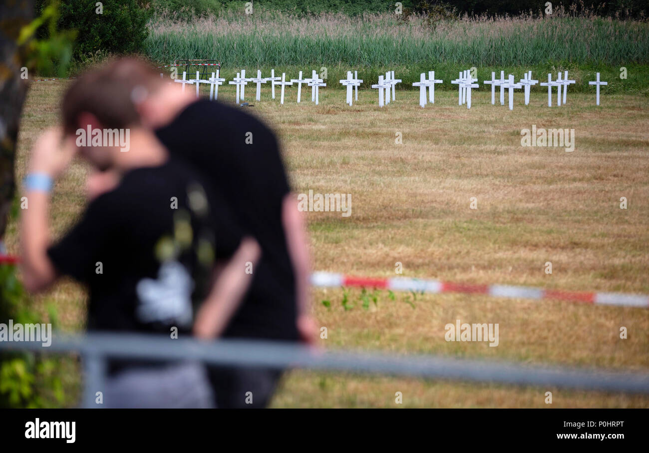 09 June 2018, Germany, Themar: Festivalgoers at the right-wing festival 'Tage der nationalen Bewegung' walk past white crosses. A total of 194 crosses were set up next to the festival site by protestors, of which 193 commemorate those killed by right-wing violence in Germany since 1990, and one commemorates Martin Luther King. The 2-day festival attracts rightists from across Europe. Several counter-protests and events are planned. Photo: FrM/dpa-Zentralbild/dpa Stock Photo