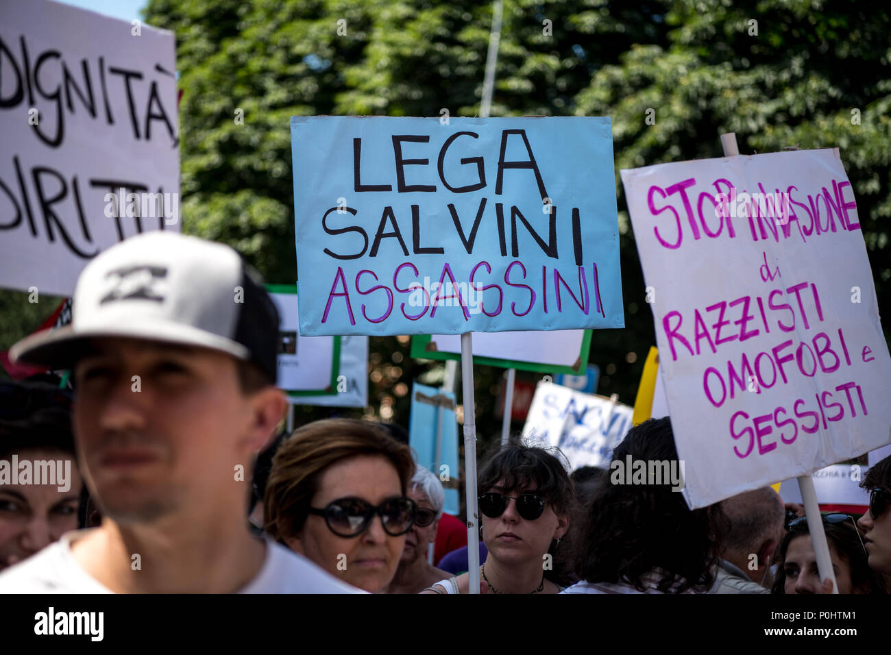 Milan, Italy - 9 June 2018: A young woman holds a placard  reading 'Lega Salvini Murderers' during an anti-racist rally against the killing of Soumaila Sacko, a  29 years old Malian farm worker migrant, murdered in a shooting last Sunday in the village of San Ferdinando in the southern Italian region of Calabria. Stock Photo