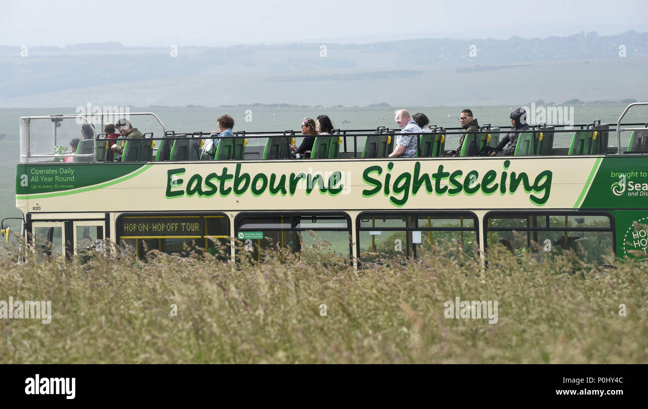 South Downs, UK.  9 June 2018.  Sightseers take a tour bus near Beachy Head on a warm afternoon.  In recent years, the area has been prone to erosion with areas of the chalk cliffs around Seven Sisters collapsing onto the beach below.  As a result walkers are warned not to go close to the cliff edge.  Credit: Stephen Chung / Alamy Live News Stock Photo
