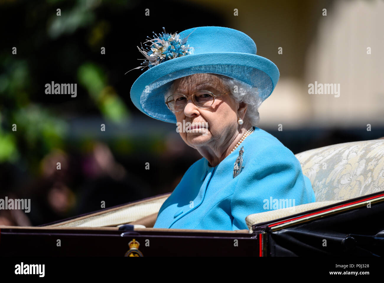 During Trooping the Colour a female threw a china mug or cup which smashed in front of The Queen's carriage. The Queen looked on as police apprehended the female. Queen in blue Angela Kelly design outfit Stock Photo
