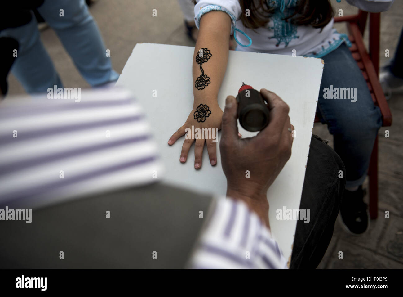Granada, Granada, Spain. 9th June, 2018. A man doing a temporary ''black henna'' tattoo before the public Iftar in Palacio de Congresos Square in Granada.During Ramadan, Granada Muslim community make a pulic Iftar in a square to share their traditions and the way they pray with other people of the city. Credit: Carlos Gil/SOPA Images/ZUMA Wire/Alamy Live News Stock Photo