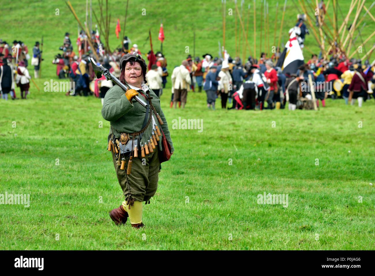 17th century military musketeer walking with musket over shoulder in back of battle lines of English Civil war Battle of Bristol Stock Photo