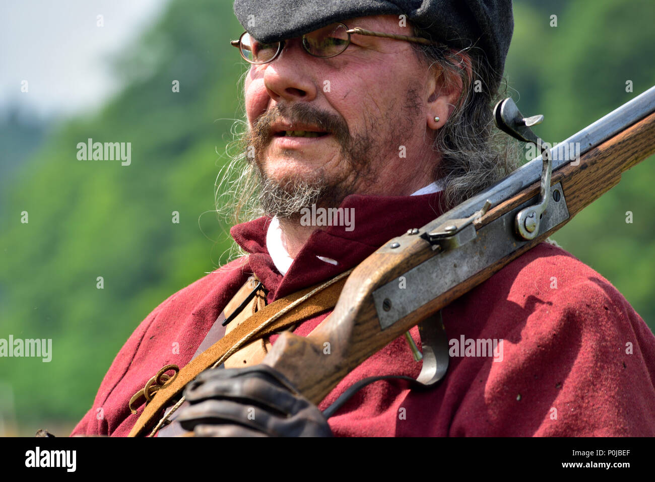 Portrait of 17th century musketeer in costume with musket over shoulder in English Civil war re-enactment Stock Photo