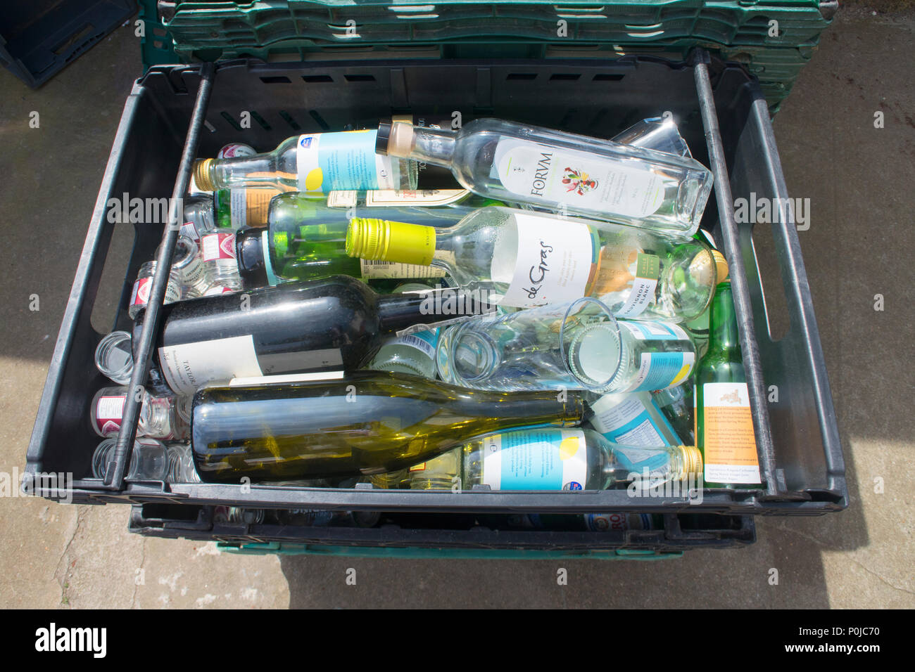 Collection of empty glass bottles waiting collection to a recycling centre - John Gollop Stock Photo